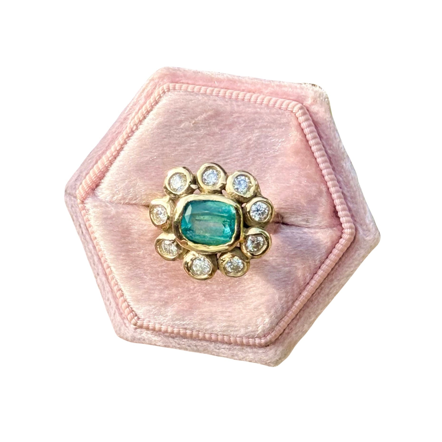 Hexagonal pink velvet jewelry box with a gemstone and gold accents on a white background