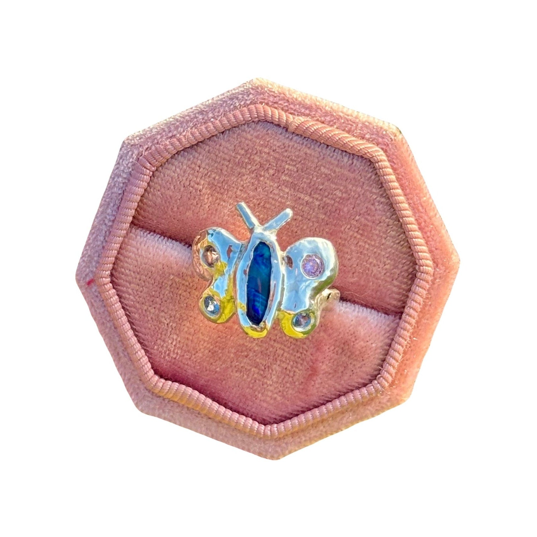 Butterfly-shaped jewelry box with a blue gemstone on a white background